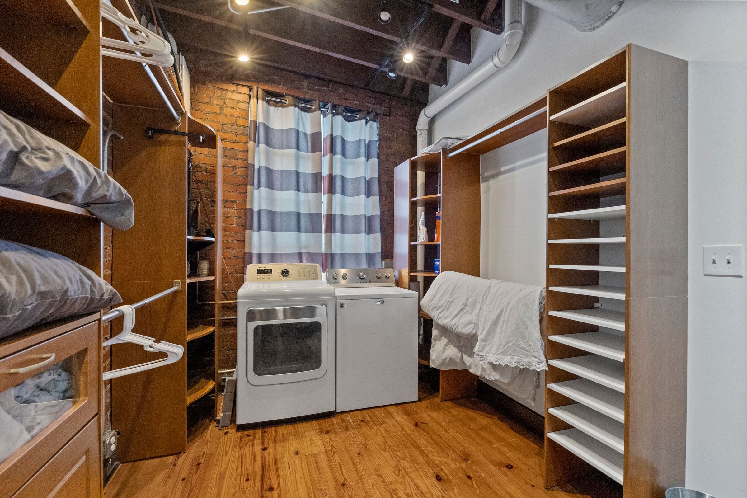 The laundry and walk-in closet: a washer and dryer, shelving and hanging space.