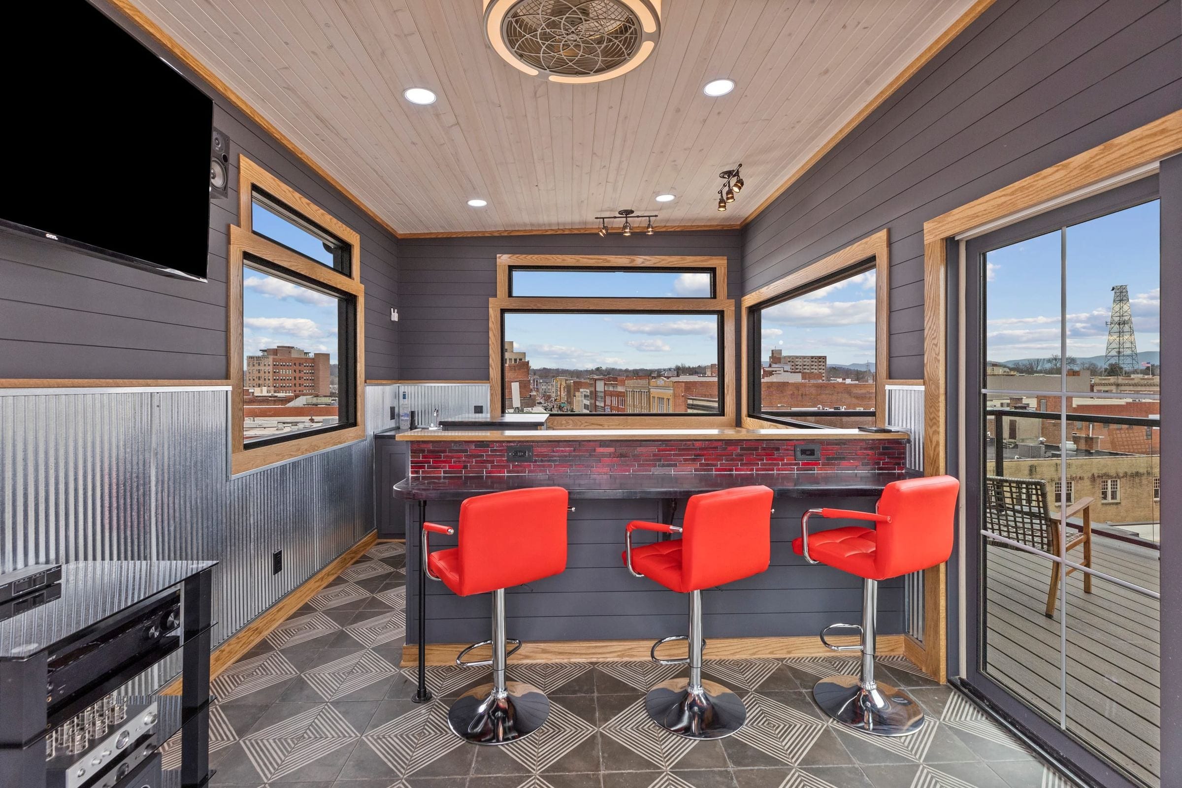 The penthouse bar: red stools, a checkerboard floor and windows on three sides.