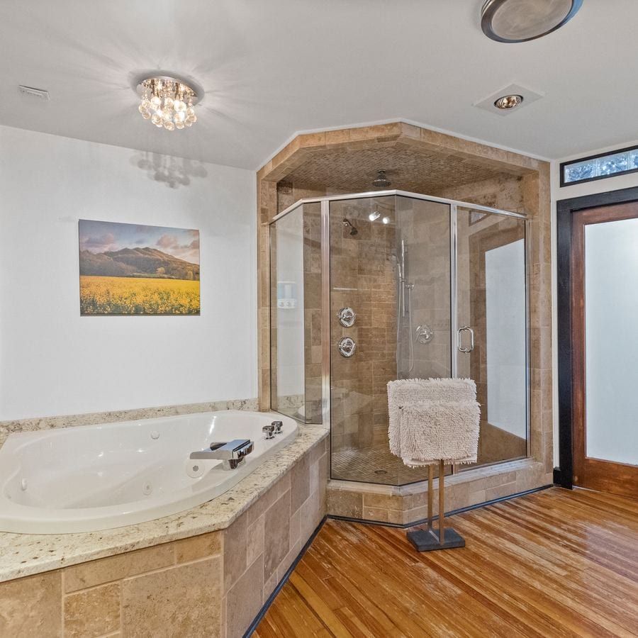 The other end of the bathroom: the jacuzzi tub and the glass corner shower.